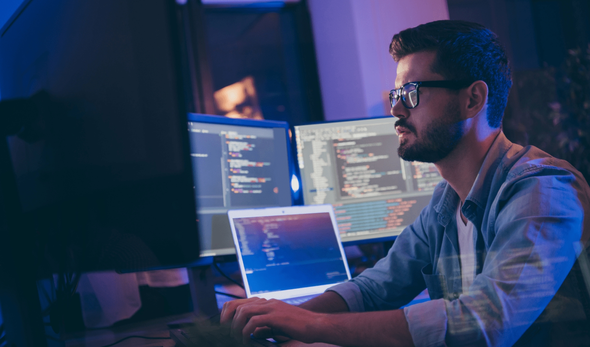 Man working on multiple monitors at once